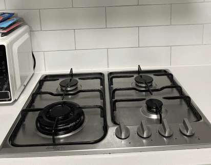 Degreased stainless steel gas cooktop after a kitchen clean
