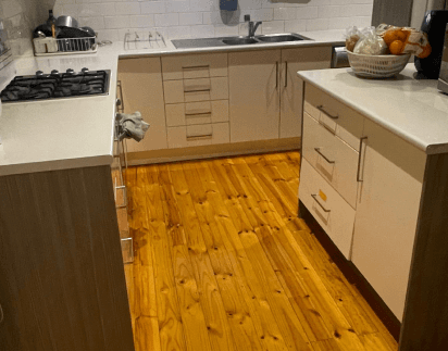 Freshly mopped timber kitchen floor with wiped-down cabinetry