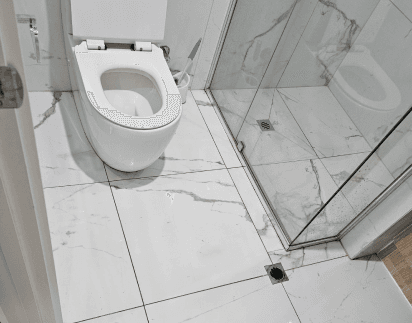 Sanitised bathroom with polished tiles and a spotless shower screen