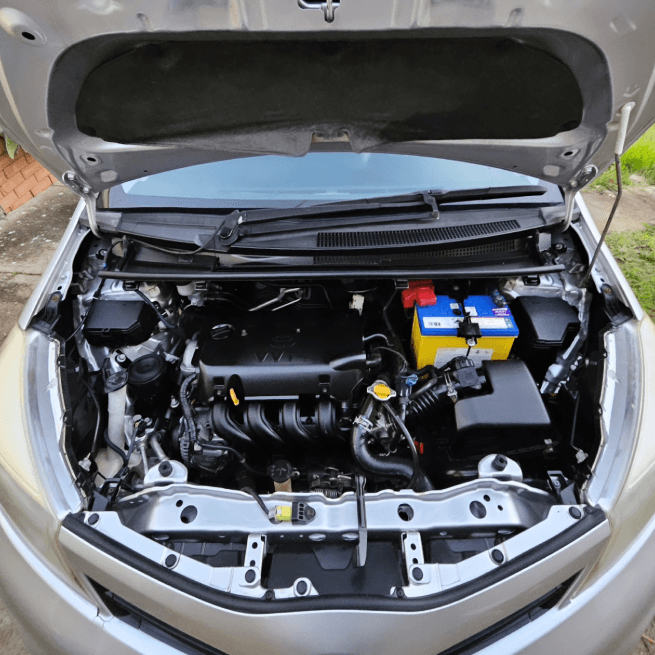 Toyota engine bay opened up for a scheduled service, battery and fluid points exposed