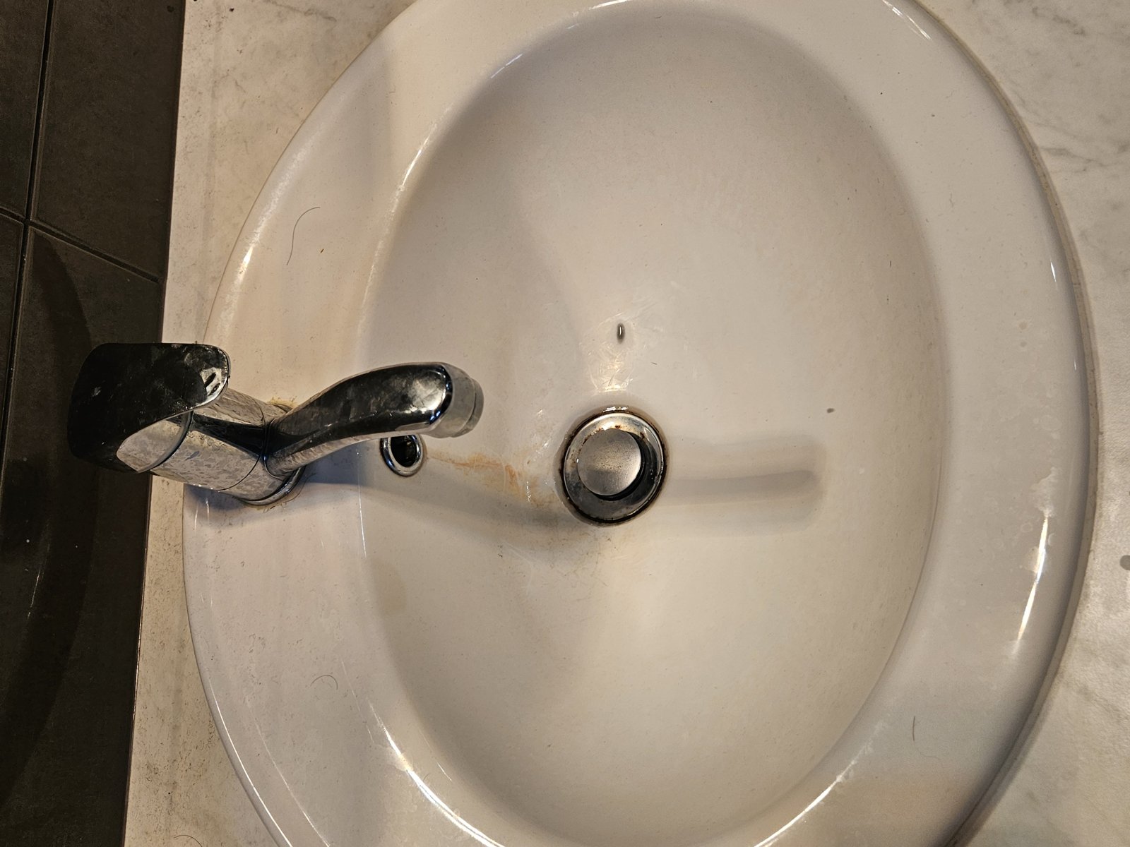 Grimy bathroom vanity basin before cleaning