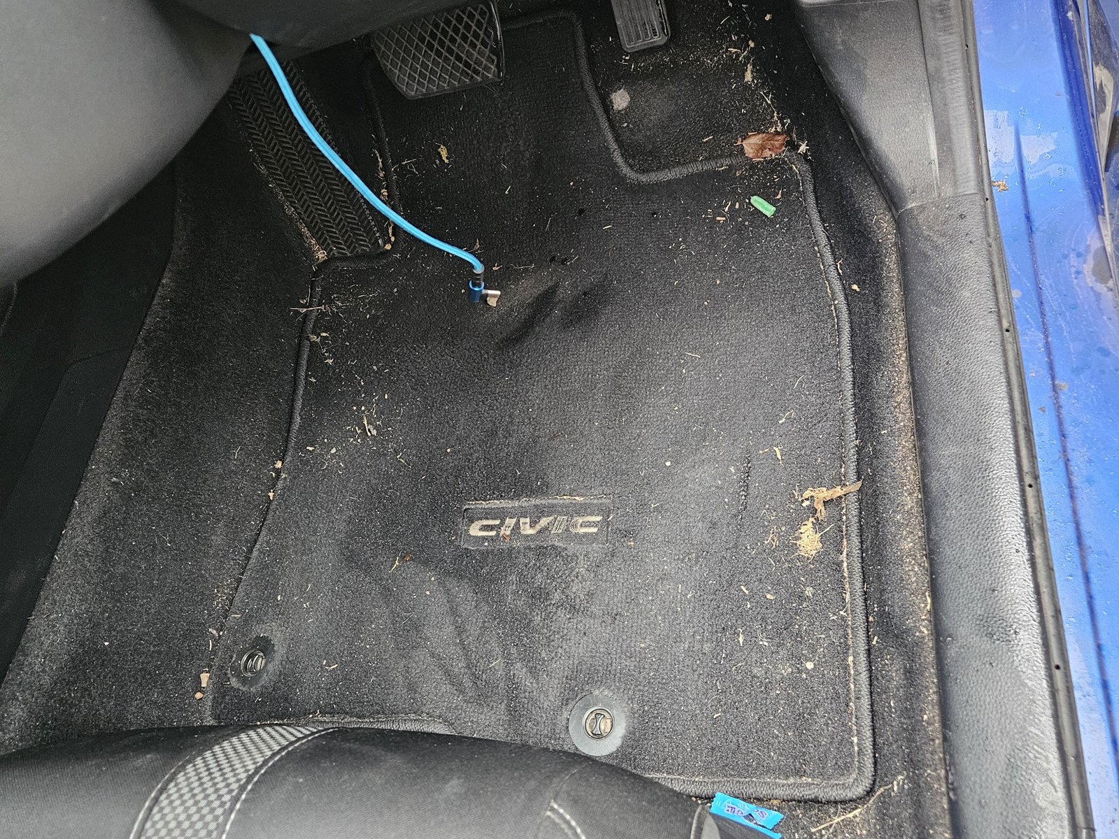 Dirty car floor mats with debris before cleaning